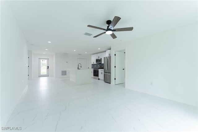 unfurnished living room with ceiling fan and sink