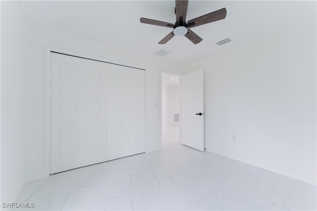 unfurnished bedroom with ceiling fan and a closet