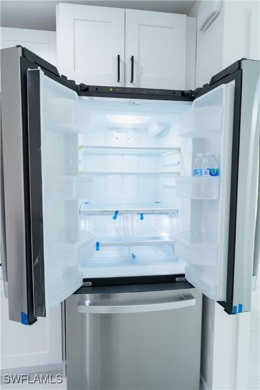 room details featuring white cabinets and fridge