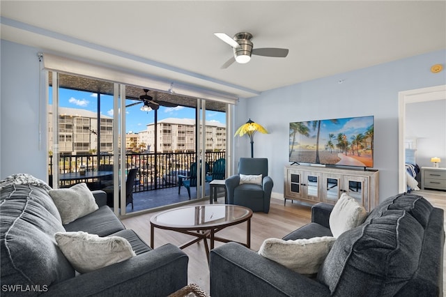 living room with ceiling fan and light hardwood / wood-style floors