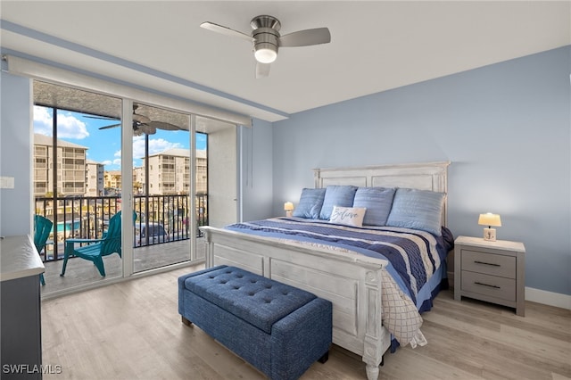 bedroom featuring ceiling fan, access to exterior, light wood-type flooring, and a wall of windows