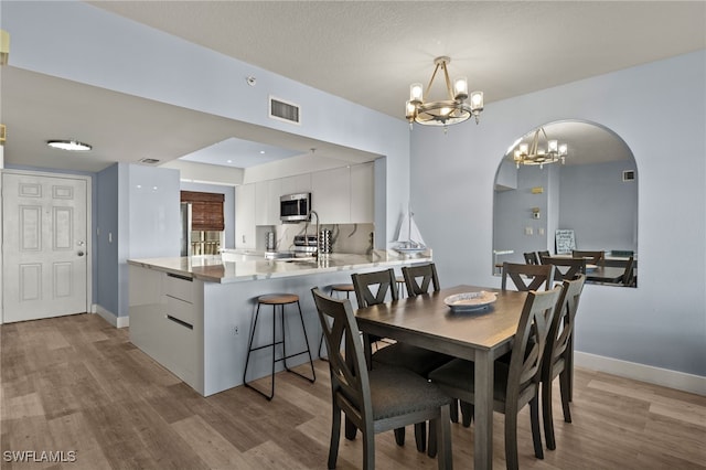 dining space featuring an inviting chandelier and light hardwood / wood-style floors