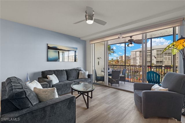 living room with ceiling fan and light hardwood / wood-style flooring