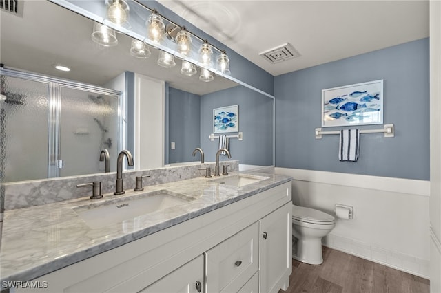 bathroom with vanity, toilet, an enclosed shower, and hardwood / wood-style floors