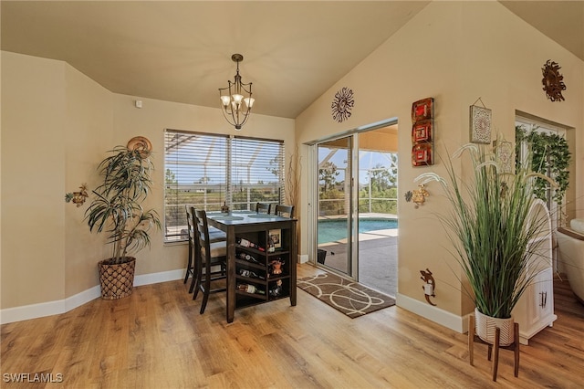 dining room featuring lofted ceiling, a notable chandelier, and light hardwood / wood-style flooring