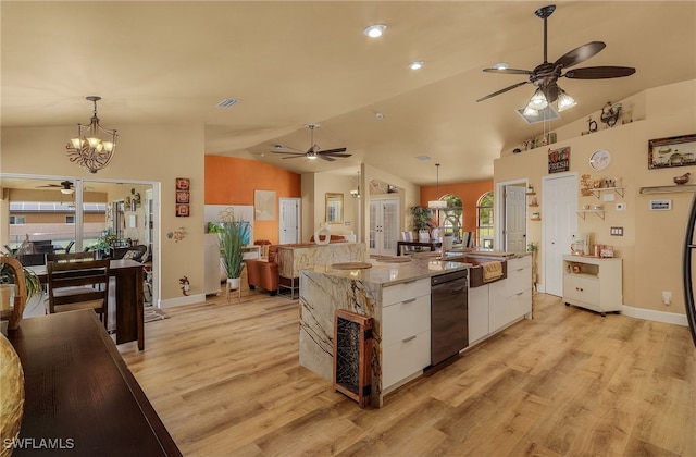 kitchen with hanging light fixtures, white cabinets, black dishwasher, and lofted ceiling