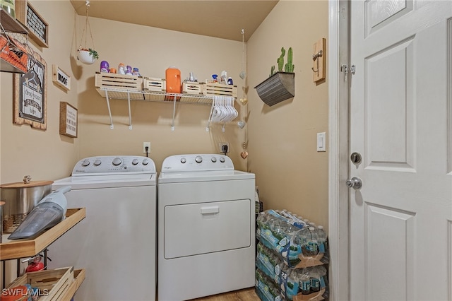 laundry room featuring separate washer and dryer and light hardwood / wood-style flooring