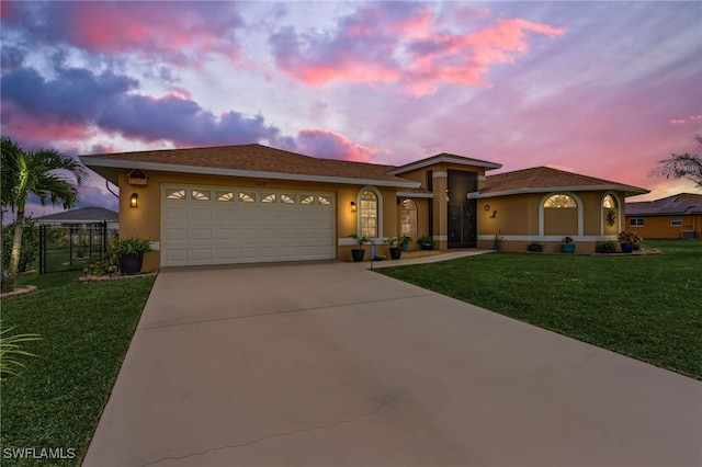 prairie-style home featuring a lawn and a garage