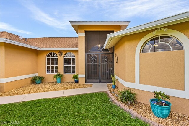 entrance to property with a lawn