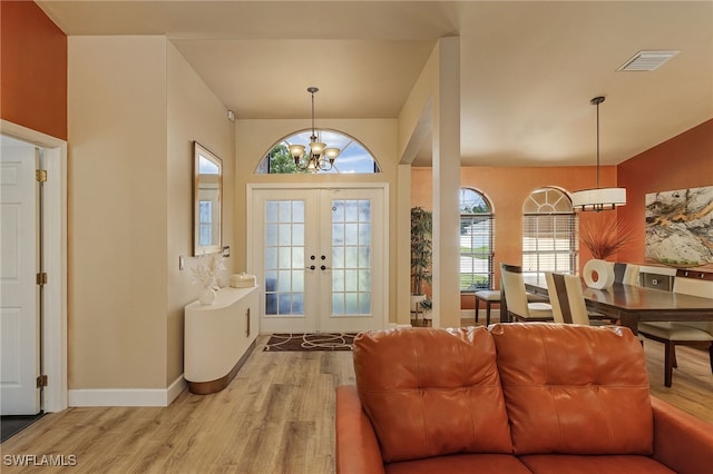 foyer featuring a chandelier, wood-type flooring, and french doors