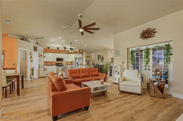 living room featuring ceiling fan, light wood-type flooring, vaulted ceiling, and french doors