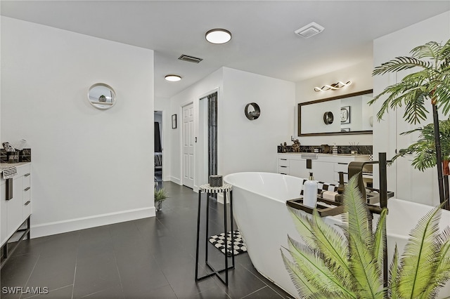 bathroom with tile patterned floors, a bathtub, and vanity