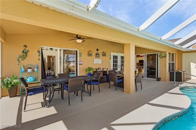 view of patio with ceiling fan, glass enclosure, and french doors