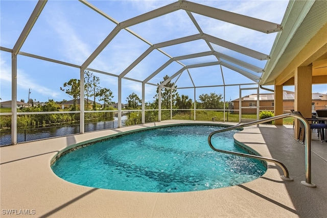 view of pool featuring glass enclosure, a water view, and a patio