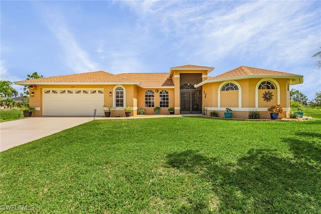 mediterranean / spanish home with a front lawn and a garage