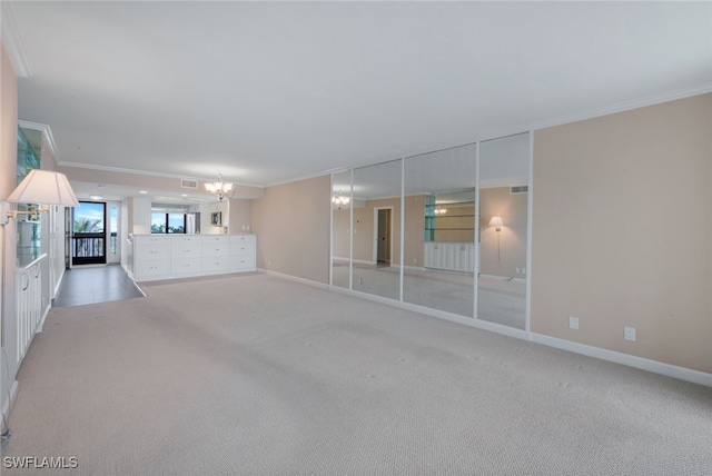 carpeted empty room with a chandelier and ornamental molding