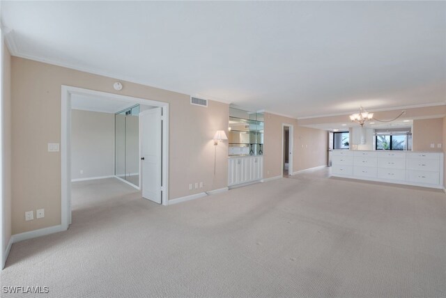 unfurnished living room with light carpet, a notable chandelier, and ornamental molding