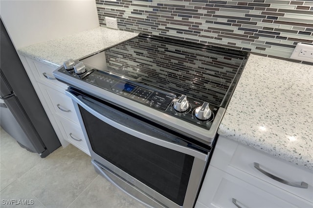 2777 W Gulf Dr Unit 309, Sanibel, FL 33957 - room details with backsplash, white cabinets, electric stove, and light stone counters
