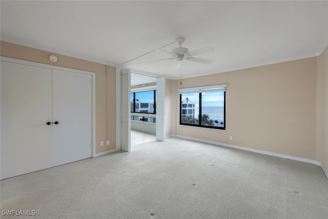 unfurnished bedroom featuring light carpet, ceiling fan, and ornamental molding