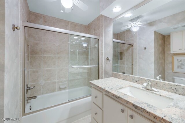 full bathroom featuring toilet, combined bath / shower with glass door, and vanity