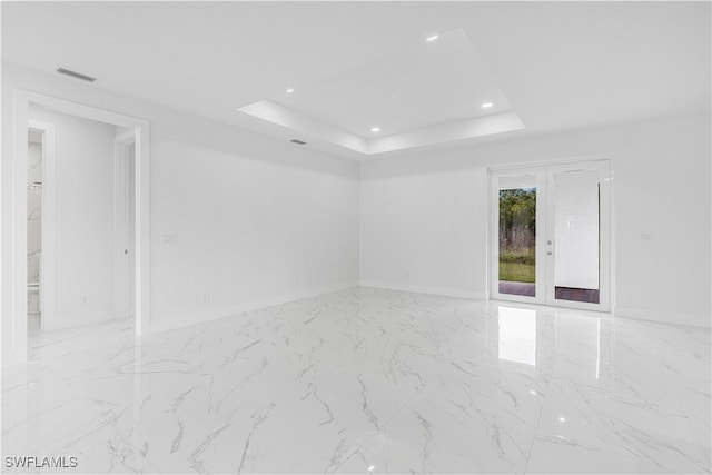 unfurnished room featuring a tray ceiling