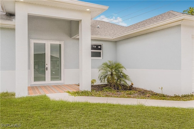 doorway to property featuring french doors and a lawn