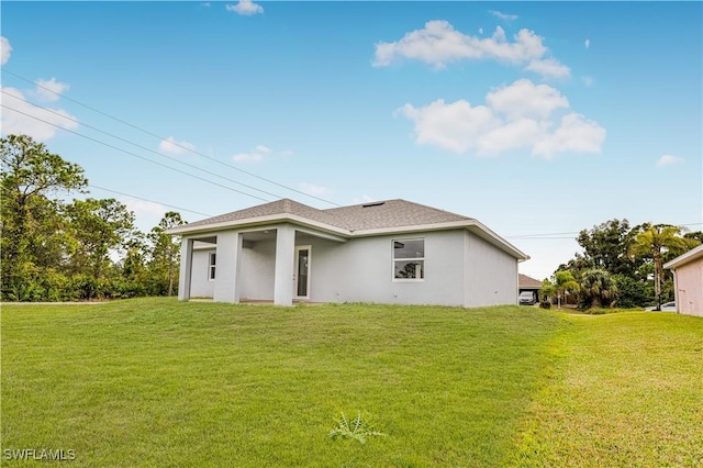 rear view of house featuring a lawn