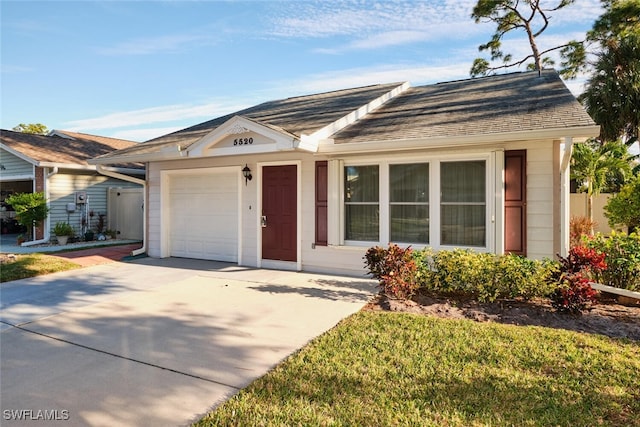 ranch-style home featuring a garage and a front lawn