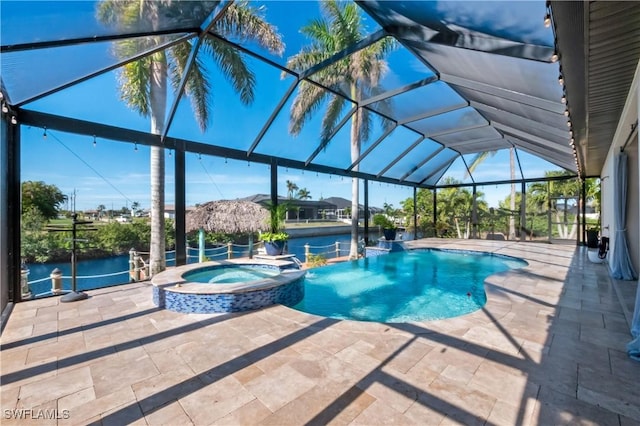 view of swimming pool featuring pool water feature, a patio area, a water view, a lanai, and an in ground hot tub