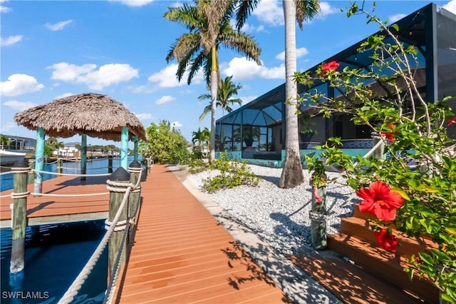 view of dock with a lanai and a gazebo