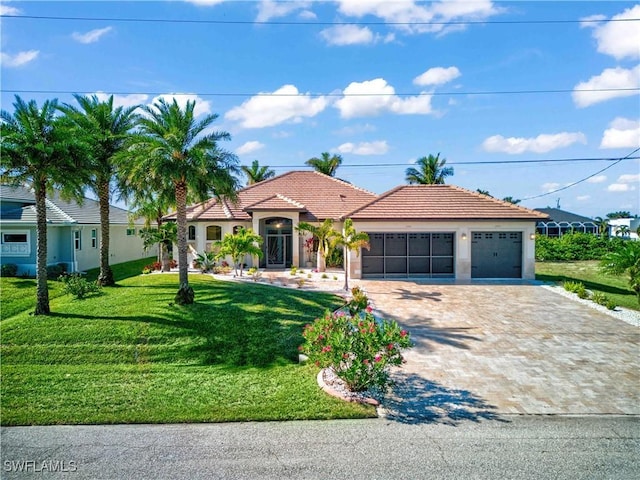 mediterranean / spanish home with a garage and a front lawn