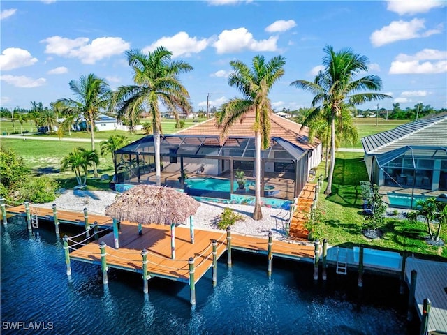 dock area featuring a yard, a water view, and glass enclosure