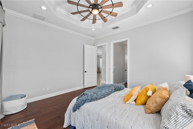 bedroom with crown molding, ceiling fan, a tray ceiling, and dark hardwood / wood-style flooring