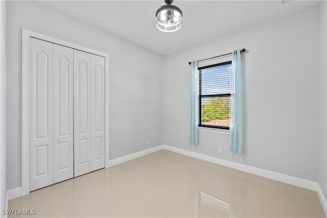 unfurnished bedroom featuring tile patterned flooring and a closet