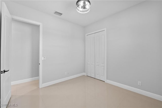 unfurnished bedroom with light tile patterned floors and a closet