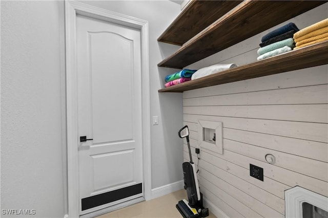 clothes washing area featuring washer hookup and wooden walls