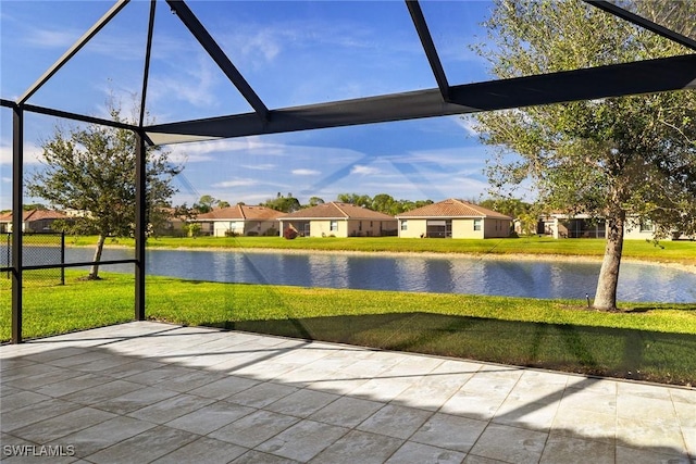 unfurnished sunroom featuring a water view and a residential view