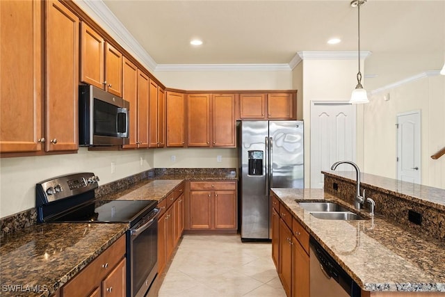 kitchen with stainless steel appliances, brown cabinets, a sink, and hanging light fixtures