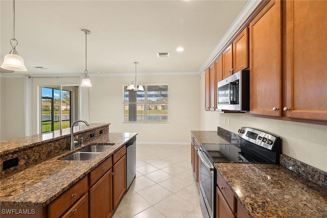 kitchen with brown cabinets, dark stone countertops, decorative light fixtures, stainless steel appliances, and a sink