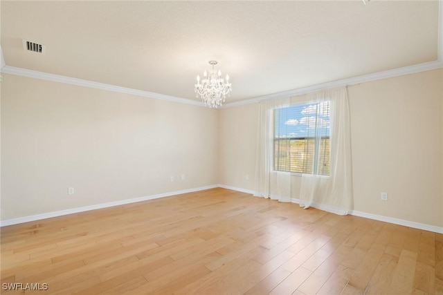 spare room with an inviting chandelier, crown molding, and light wood-type flooring