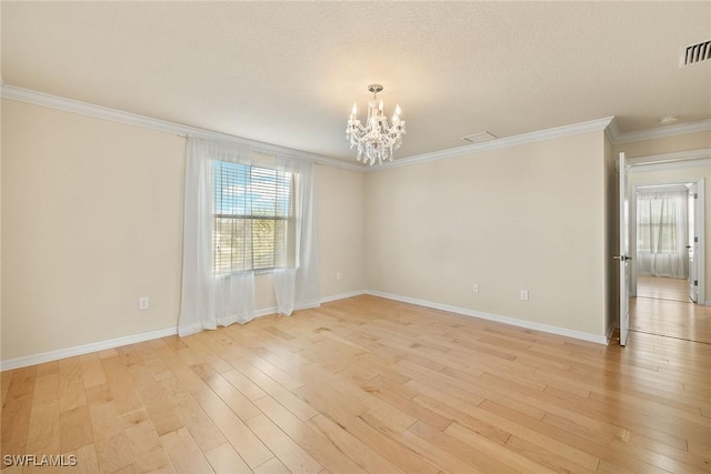 spare room with a notable chandelier, light wood finished floors, ornamental molding, a textured ceiling, and baseboards