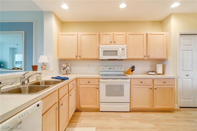 kitchen with white appliances, light brown cabinets, decorative backsplash, sink, and light hardwood / wood-style flooring