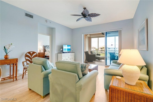 living room with ceiling fan and light hardwood / wood-style flooring