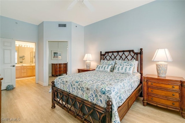 bedroom with ceiling fan, connected bathroom, and light hardwood / wood-style flooring