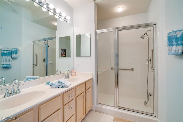 bathroom with a shower with shower door, vanity, and tile patterned floors