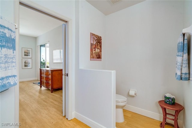 bathroom with toilet and wood-type flooring