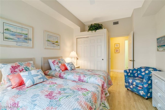 bedroom featuring ceiling fan, a closet, and light hardwood / wood-style flooring