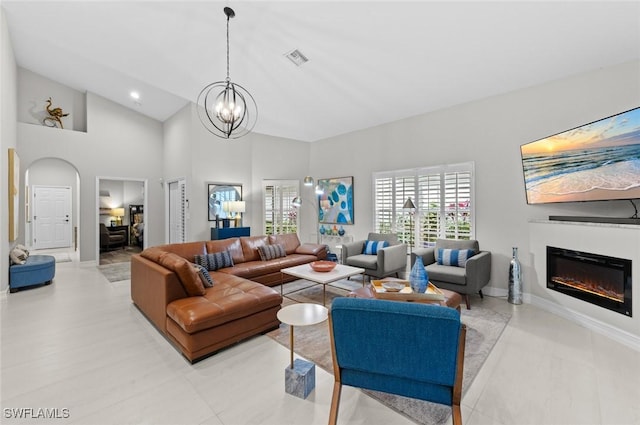 living room with a chandelier and high vaulted ceiling