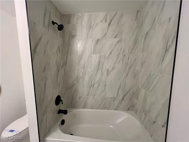 bathroom with toilet and tiled shower / bath combo