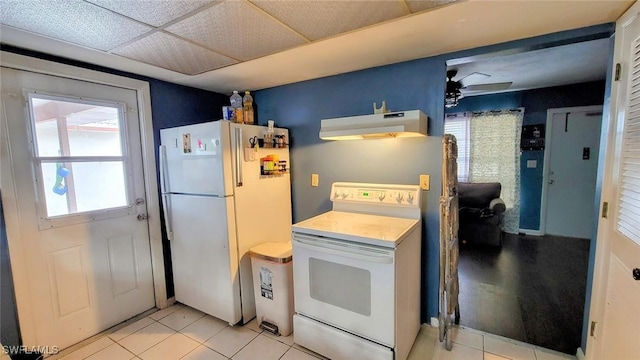 kitchen with ceiling fan, white appliances, a wealth of natural light, and light tile patterned flooring